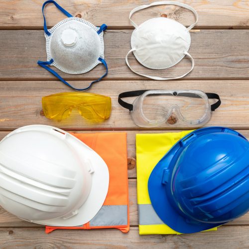 Work safety protection equipment on wooden background.