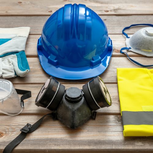 Work safety protection equipment on wooden background.