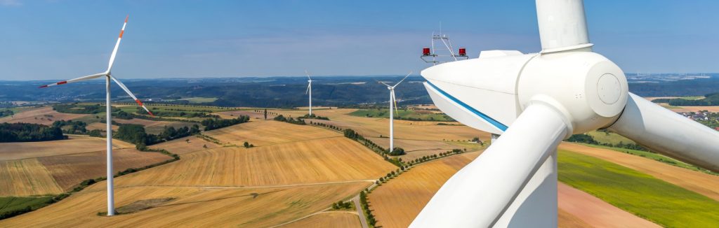 Banner Luftbild und Nahaufnahme einer Windenergieanlage