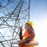 construction worker checking location site near to High voltage tower. construction worker checking location site near to High voltage tower.