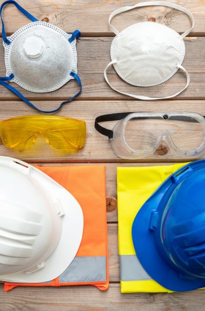 Work safety protection equipment on wooden background.